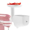 A white food grinder attachment for a red KitchenAid stand mixer, with sliced tomatoes in the hopper. Voir les images du produit