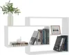 A white, modern, geometrically shaped bookshelf filled with books and a framed picture. Produktbild-Vorschau