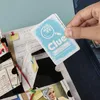 A hand holding a Clue advent calendar card over an open advent calendar. Produktbild-Vorschau