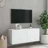 A white wall-mounted TV cabinet with a TV mounted above it, and a plant in a pot to the right. Produktbild-Vorschau