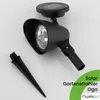 A black solar garden spotlight with an attached ground stake is shown against a white background. Text and a logo are overlaid on the bottom right. Produktbild-Vorschau