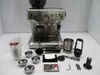 A silver espresso machine with various accessories laid out in front of it on a white surface. Produktbild-Vorschau
