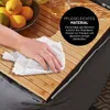 A hand cleaning a bamboo surface. Produktbild-Vorschau