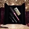 A GHD hair styling set displayed in an open case, against a sparkling gold background. Produktbild-Vorschau