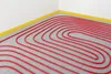 A room corner with underfloor heating pipes laid out on a gray grid. Náhľad obrázku produktu