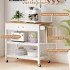 A white kitchen cart with a wooden top, featuring an espresso machine, toaster, plates, and a pot. It has a drawer, open shelves, and towel racks on the side. Text overlays highlight features. Náhled obrázku produktu