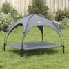A gray dog bed with a canopy sits on a grassy lawn in front of a wooden fence and bushes. Anteprima dell’immagine prodotto