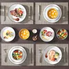 A top-down view of a table setting with multiple plates of food and cutlery. Náhled obrázku produktu
