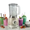 A retro-style blender with a glass pitcher filled with ice, surrounded by colorful smoothies and fresh strawberries. Produktbild-Vorschau