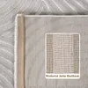 A close-up view of the underside of a rug, showing the natural jute bottom and the texture of the rug's pile. Náhled obrázku produktu