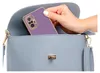 A hand is placing a purple phone case into a light blue purse. Produktbild-Vorschau