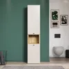 A tall, narrow bathroom cabinet with a wood-accented open shelf is shown against a green wall, with a toilet and framed artwork visible in the background. Produktbild-Vorschau