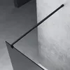 A black shower rod and a gray glass shower panel are shown in a modern bathroom setting with concrete walls and floor. Produktbild-Vorschau