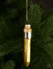 A glass Christmas ornament shaped like a pencil, hanging on a Christmas tree. Podgląd zdjęcia produktu