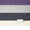 A close-up view of a striped fabric with a brand label. Podgląd zdjęcia produktu