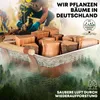 People planting a tree with a basket of firewood in the foreground, set against a misty forest background. Produktbild-Vorschau