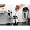 A hand is using a scoop to add coffee grounds to a moka pot. Voir les images du produit