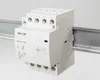 A white electrical relay mounted on a metal DIN rail against a white background. Produktbild-Vorschau