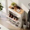 A shoe cabinet with shoes, umbrellas, and a coat rack in a hallway. Produktbild-Vorschau