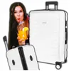 A woman is peeking from behind a large white suitcase, holding a drink. Produktbild-Vorschau