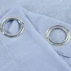 A close-up view of two grommets on a light blue fabric. Produktbild-Vorschau