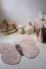 A child's room with a rocking horse, mushroom-shaped stools, and a butterfly rug. Voir les images du produit