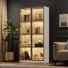 A well-lit display cabinet filled with decorative items and books, placed in a modern living room setting. Náhľad obrázku produktu