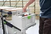 A person is holding a toolbox on a workbench in a workshop. Anteprima dell’immagine prodotto