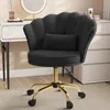 A black velvet office chair with a scalloped back and a small pillow, placed in front of a white vanity table with a lighted mirror. Voir les images du produit