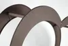 A close-up view of a metal firewood rack with a heart shape. Produktbild-Vorschau
