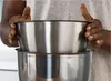 A person's hands are holding two stacked stainless steel bowls. Voir les images du produit