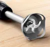 Close-up of the blade assembly of an immersion blender resting on a wooden surface. Produktbild-Vorschau