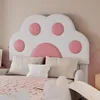 A close-up view of a child's bed with a playful, cat-paw-shaped headboard. Produktbild-Vorschau