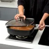 A person is cooking in a kitchen, using a square pot on a stovetop. Náhled obrázku produktu