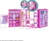 A Barbie Dream Wardrobe playset is displayed open, with a Barbie doll standing next to it. The playset is pink and features compartments for clothes, shoes, and accessories. A rack with dresses is on the left, and a vanity area is in the center. Produktbild-Vorschau