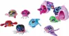 A collection of small, plush sea creatures and their carrying cases, arranged on a white background. Produktbild-Vorschau