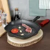 A cast iron grill pan with a lamb chop, tomato, and garlic cloves on a wooden surface, with kitchen accessories in the background. Voir les images du produit