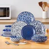 A collection of blue and white patterned ceramic dishes arranged on a wooden table, with a microwave in the background. Produktbild-Vorschau