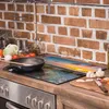 A kitchen counter with a stove, a cutting board, and various cooking ingredients. Náhľad obrázku produktu