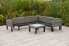 An outdoor sectional sofa and coffee table set on a patio with greenery in the background. Produktbild-Vorschau