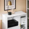 A close-up view of a white sideboard with a black printer on the left shelf and a glass-doored cabinet on the right. Produktbild-Vorschau