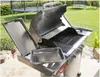 A stainless steel gas grill with its lid open, placed on a patio with a grassy backyard and trampolines in the background. Podgląd zdjęcia produktu