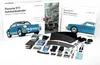 A collection of items for a Porsche 911 Advent Calendar, including model car parts, a book, and accessories, laid out on a white surface. Náhľad obrázku produktu