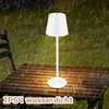 A white LED table lamp is placed on a wet wooden table outdoors at night, with rain falling. Náhľad obrázku produktu