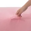 A hand is shown pulling on a pink fabric strap, which is part of a larger pink textile product. The fabric has a ribbed texture. Náhled obrázku produktu