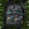 A top-down view of a bed with a floral-patterned duvet and pillows, surrounded by lush green foliage. Produktbild-Vorschau