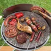 Weiße Grillmatte aus Netz auf einem runden Grill, bedeckt mit verschiedenen gegrillten Fleisch- und Gemüsesorten Productafbeelding-voorbeeld