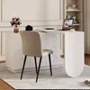 A modern white L-shaped desk with a laptop, camera, and flowers on it, with a chair in front. Podgląd zdjęcia produktu