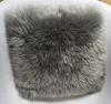 A close-up view of a gray, fluffy sheepskin seat cushion. Produktbild-Vorschau
