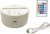 A product shot of a night light base, a remote control, and a USB cable on a white background. Voir les images du produit